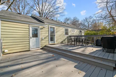 Two-level back deck with a dining table, chairs, and a covered grill