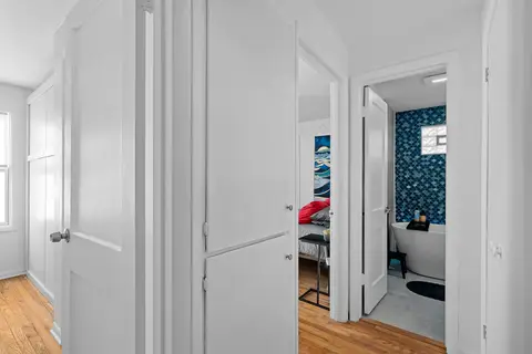 Hallway to a bedroom and a bathroom with a freestanding tub