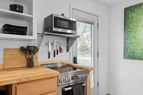 Stainless range and microwave, with a magnetic knife rack on the wall