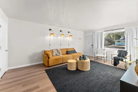 Living room with a sofa, an armchair, and a bright front window