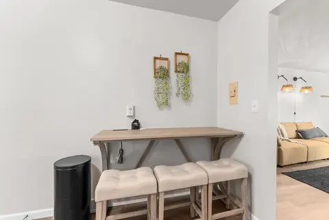 Counter-height table with three stools under two hanging plants