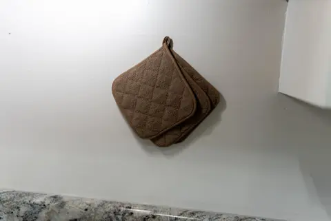 Quilted pot holders hanging on a white wall