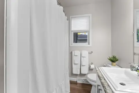 Bathroom with a white sink, a toilet, and a shower curtain