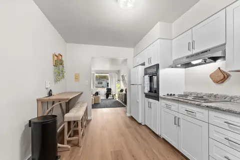 Hallway past a counter with stools into the kitchen