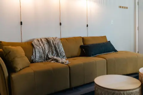 Mustard sofa with a knit throw and a navy pillow