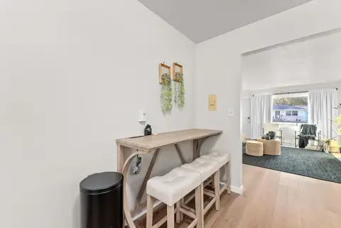 Counter with three cushioned stools, looking through to the living room