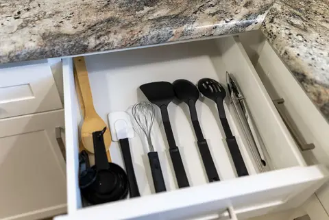 Drawer of cooking utensils, including a whisk and spatulas