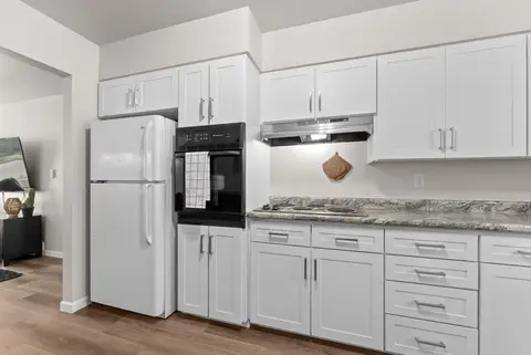 White refrigerator and wall oven beside granite counters