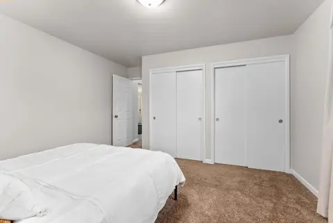 Queen bed facing a white double closet