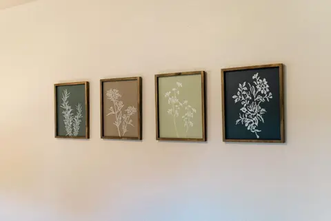 Four framed botanical prints on a bedroom wall