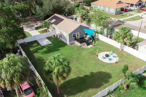 Aerial view of the fenced backyard, with the fire pit circle and the shaded deck