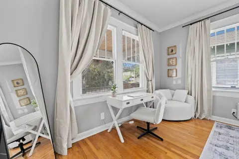 Desk and office chair by the window, with an armchair and a floor mirror