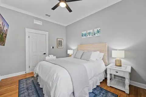 Queen bedroom with a woven headboard and a white nightstand