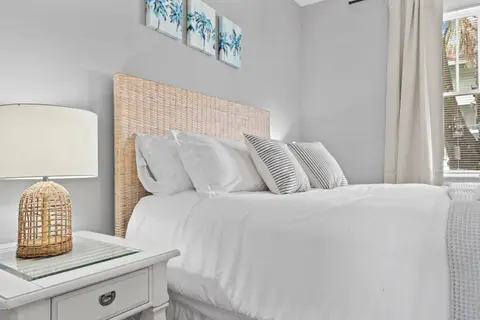 Queen bed with a woven headboard and a rattan lamp