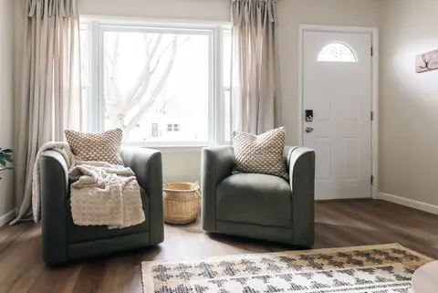 Two green armchairs by the front window