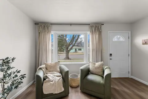 Two green armchairs under the front window, beside the front door