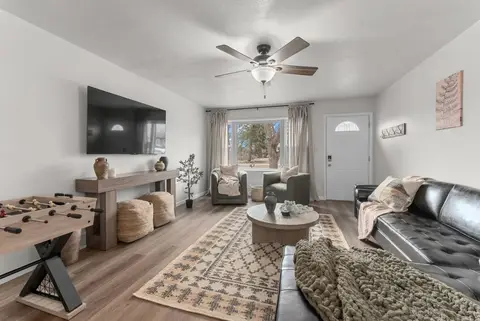 Living room with a leather sectional, a TV console, and the front window