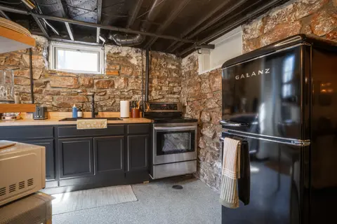 Kitchen with a black retro fridge, an electric range, and butcher block counters