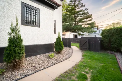 Side path along the stucco building to the backyard gate