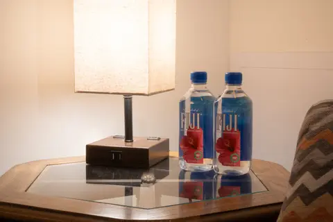 Side table with a lamp and two bottles of water