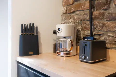 Knife block, coffee maker, and toaster on the butcher block counter