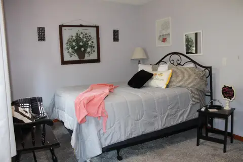 Queen bed with a wrought-iron headboard and a bench at the foot
