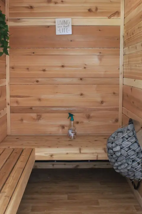 Sauna bench and stone heater under a small sign
