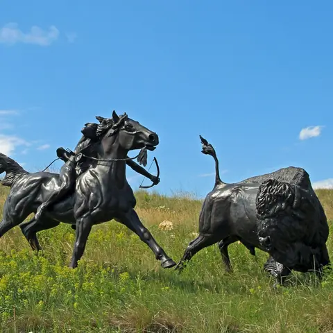 Bronze sculpture of a rider chasing a bison