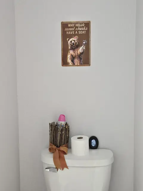 Toilet with a bear sign above it