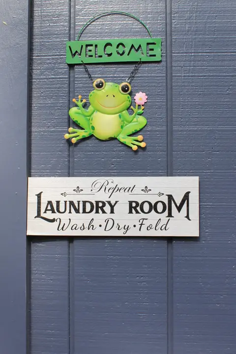 Welcome sign with a frog above a laundry room sign
