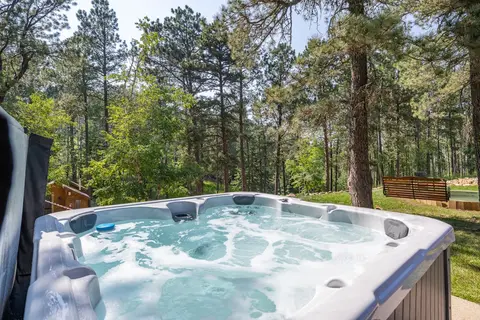 Shared hot tub with a view of the pines and lawn