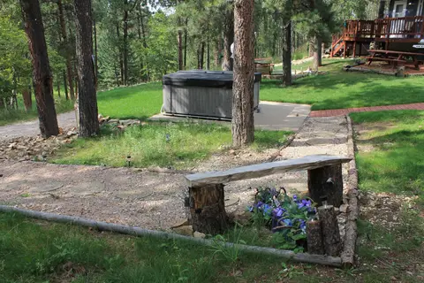 Log bench by a flower bed along a gravel path