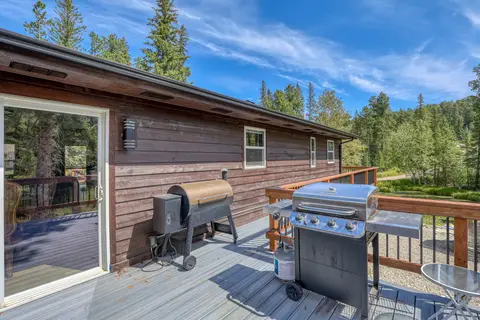 Deck with a gas grill and a smoker beside the sliding door