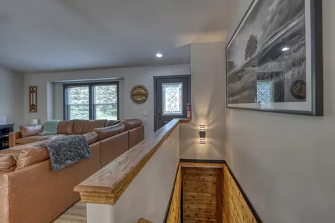 Staircase down to the lower level beside the living room sectional