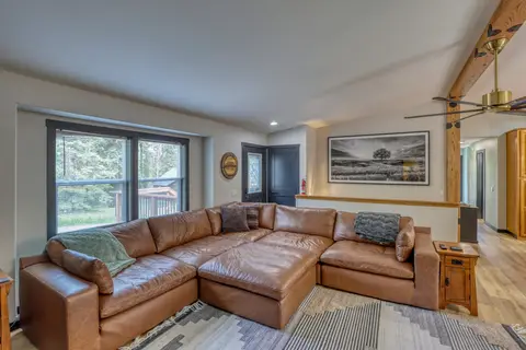 Leather sectional with throw blankets facing big windows in the living room