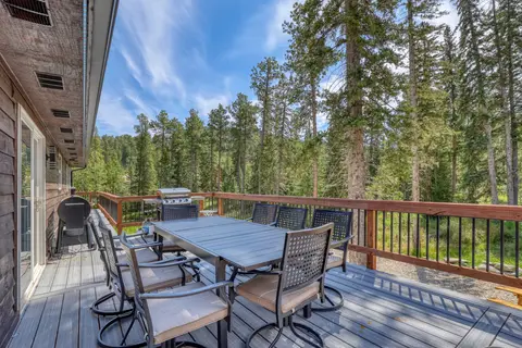 Deck dining table with swivel chairs overlooking the pines