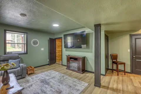 Family room with a TV over an electric fireplace and a recliner