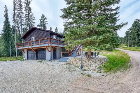 Garage end of the house with two garage doors and stairs to the deck