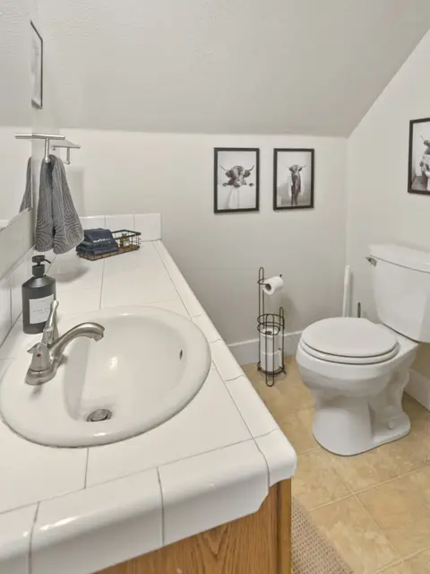 Bathroom with a tiled vanity and a toilet