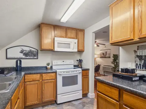 Kitchen with a white range, a microwave, and wood cabinets