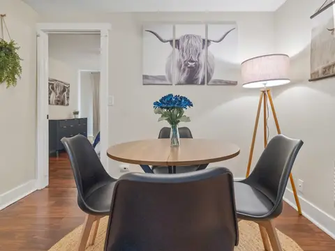 Round dining table by a doorway and a floor lamp