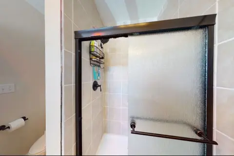 Tiled shower with a framed glass door
