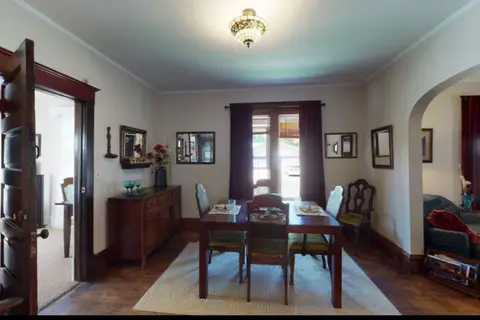 Dining room with a wood table, upholstered chairs, a sideboard, and a ceiling light