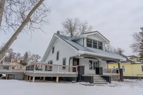 Side deck and covered front porch with brick columns, in winter