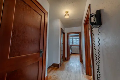 Hallway with wood doors and a vintage wall phone