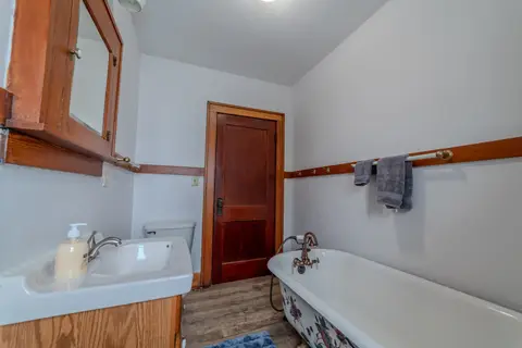 Bathroom with a clawfoot tub, a sink, and a wood medicine cabinet