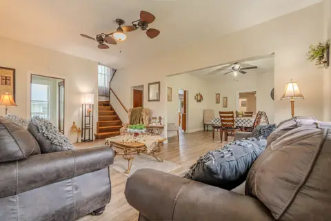 Living room with gray sofas and the staircase, open to the dining area
