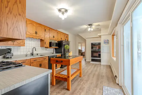 Kitchen counter with a tile backsplash, a coffee maker, and a double wall oven