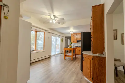 Kitchen and dining area with a ceiling fan, windows, and a sliding glass door