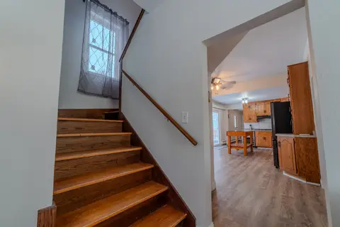 Wood staircase to the upper floor, beside the kitchen